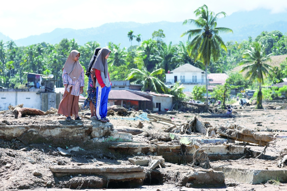 Local residents inspect an area hit by deadly flash floods following heavy rains in Palembayan, Agam regency, West Sumatra province, Indonesia, December 1, 2025. REUTERS/Willy Kurniawan