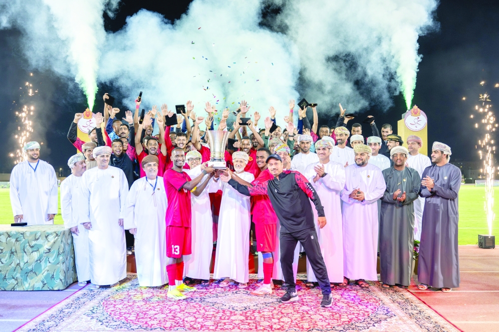 Royal Court Affairs Security Unit players receive the champions trophy from Nasr bin Hamoud al Kindi.