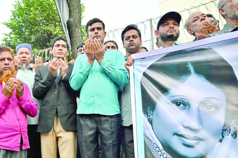 Activists in support of Bangladesh's former prime minister Khaleda Zia hold a banner with her portrait as they pray for her recovery in front of the Evercare Hospital in Dhaka. - AFP