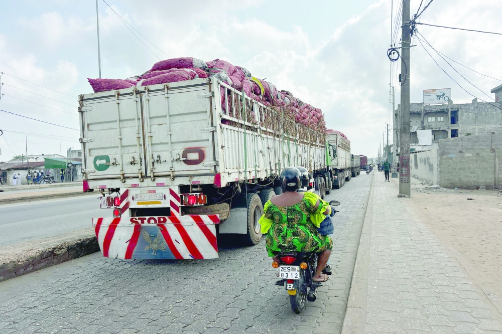 A long line of trucks stands still in Cotonou following rumors of a possible coup in the country. — AFP
