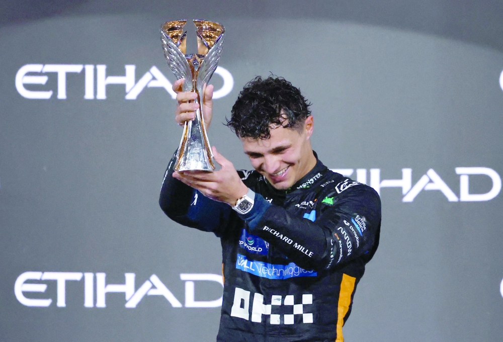 McLaren's Lando Norris celebrates on the podium with the trophy after becoming the 2025 Formula One World Champion. — Reuters