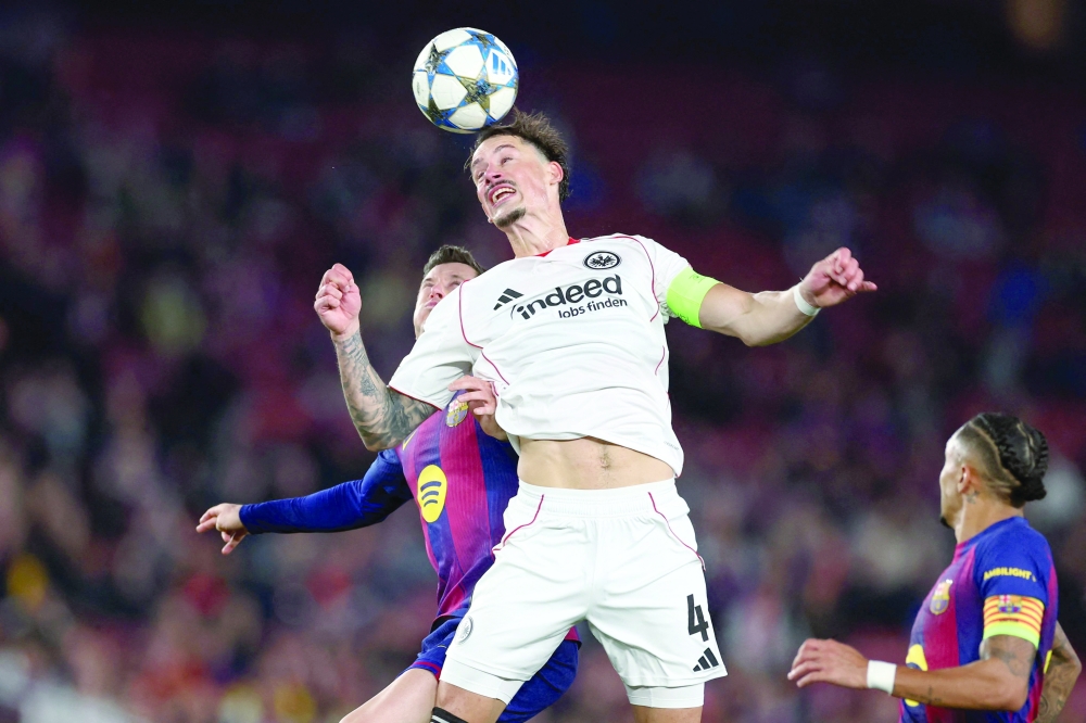 Frankfurt's German defender #04 Robin Koch (C) heads the ball challenged by Barcelona's Polish forward #09 Robert Lewandowski (L) and Barcelona's Brazilian forward #11 Raphinha. — AFP