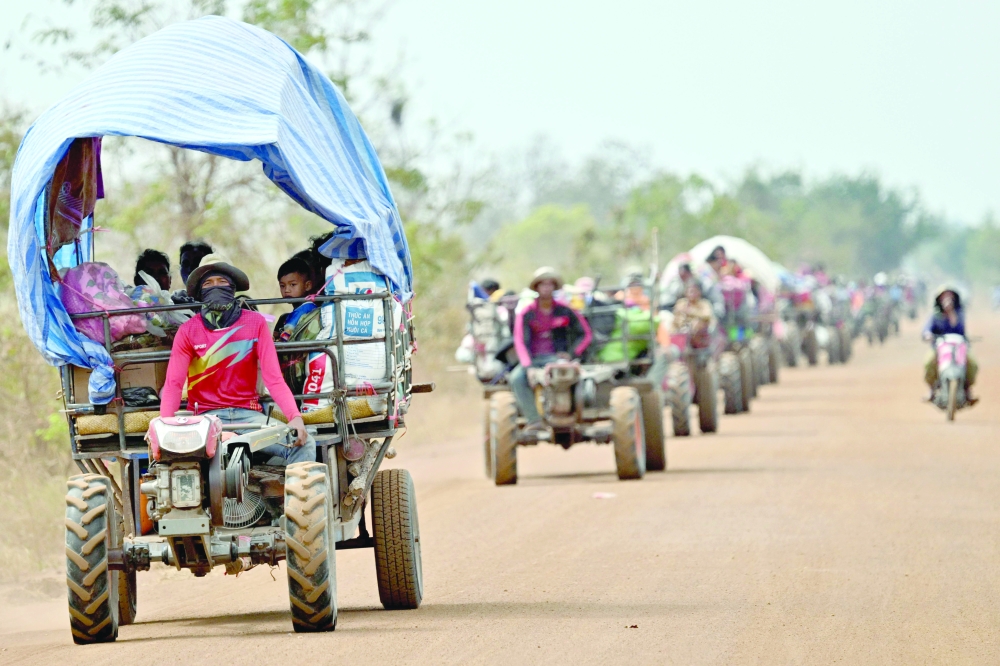 Displaced residents evacuate with their belongings along the border in Cambodia's Siem Reap province. — AFP 