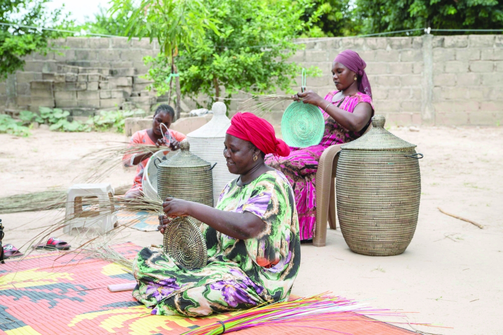 A woman makes colourful Senegalese handicraft baskets in Thiembe. — AFP