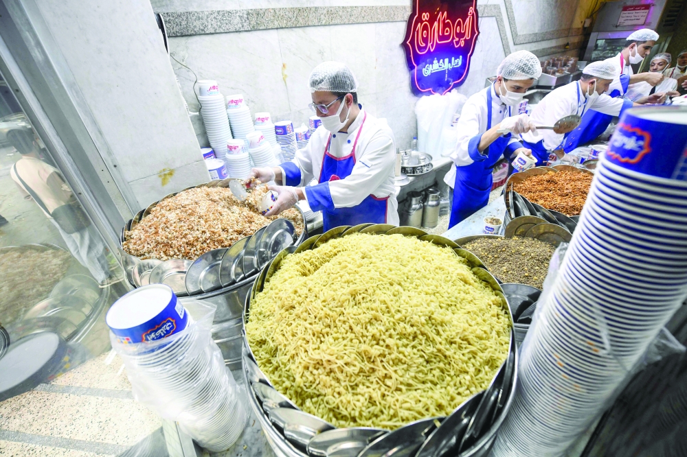 Chefs prepare a Koshary at Abou Tarek restaurant downtown Cairo. — AFP