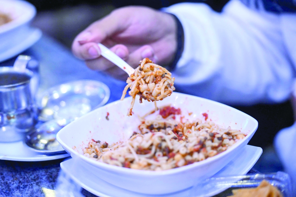 A man eats Koshary at Abou Tarek restaurant downtown Cairo. — AFP