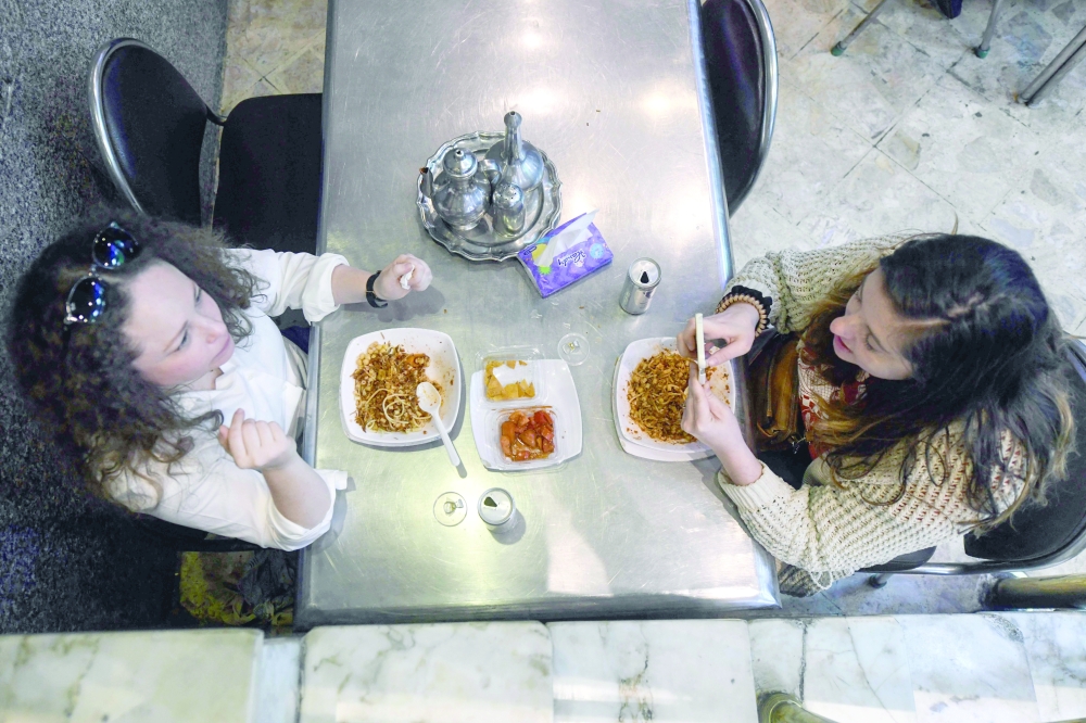 People eat Koshary in Cairo. — AFP