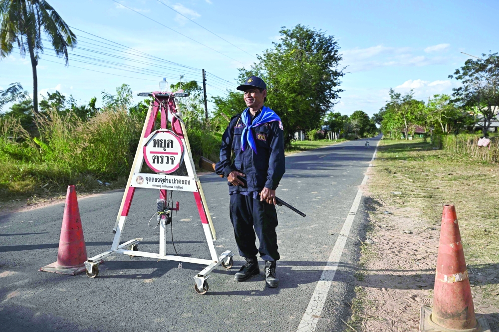 A security volunteer stands as he remains in the evacuation zone in the Thai province of Buriram. — AFP