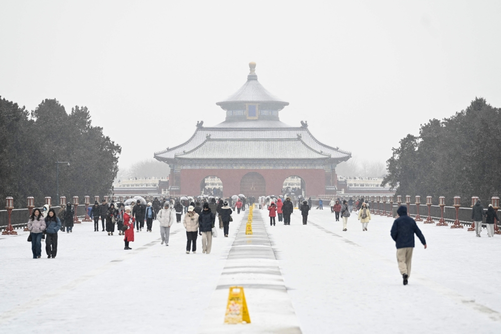 People visit the Temple of Heaven on a snowy day in Beijing