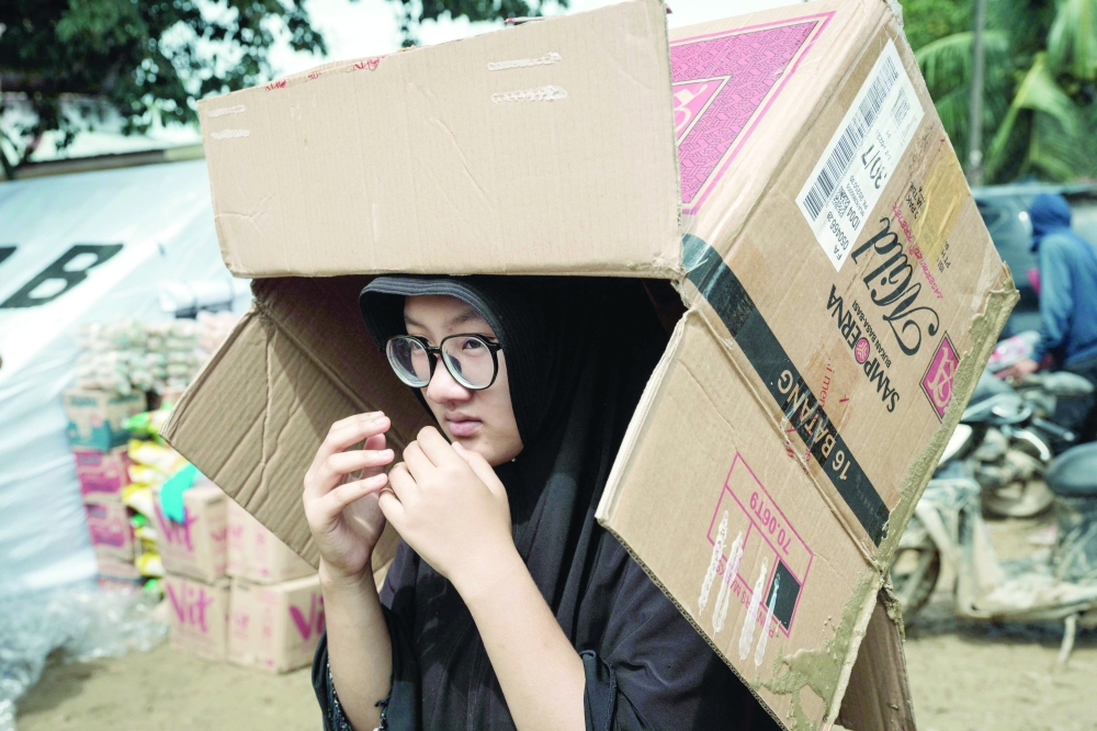 A woman waits to receive privately donated aid in an area affected by a flash flood about three weeks ago in Aceh Tamiang, Northern Sumatra. — AFP