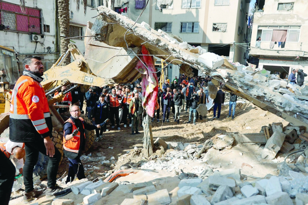 Members of the Palestinian civil defence search for the bodies of the Salem family in the rubble of a building destroyed in 2023 in the Rimal neighbourhood of Gaza City on December 15, 2025. The United States, alongside Qatar and Egypt, secured a truce in Gaza that came into effect on October 10 and has mostly halted two years of war between Israel and Palestinian militant group Hamas. More than 70,000 people have been killed in Gaza since the outbreak of the war, according to figures from the health ministry in the Hamas-run territory that the United Nations considers reliable. (Photo by Omar AL-QATTAA / AFP)