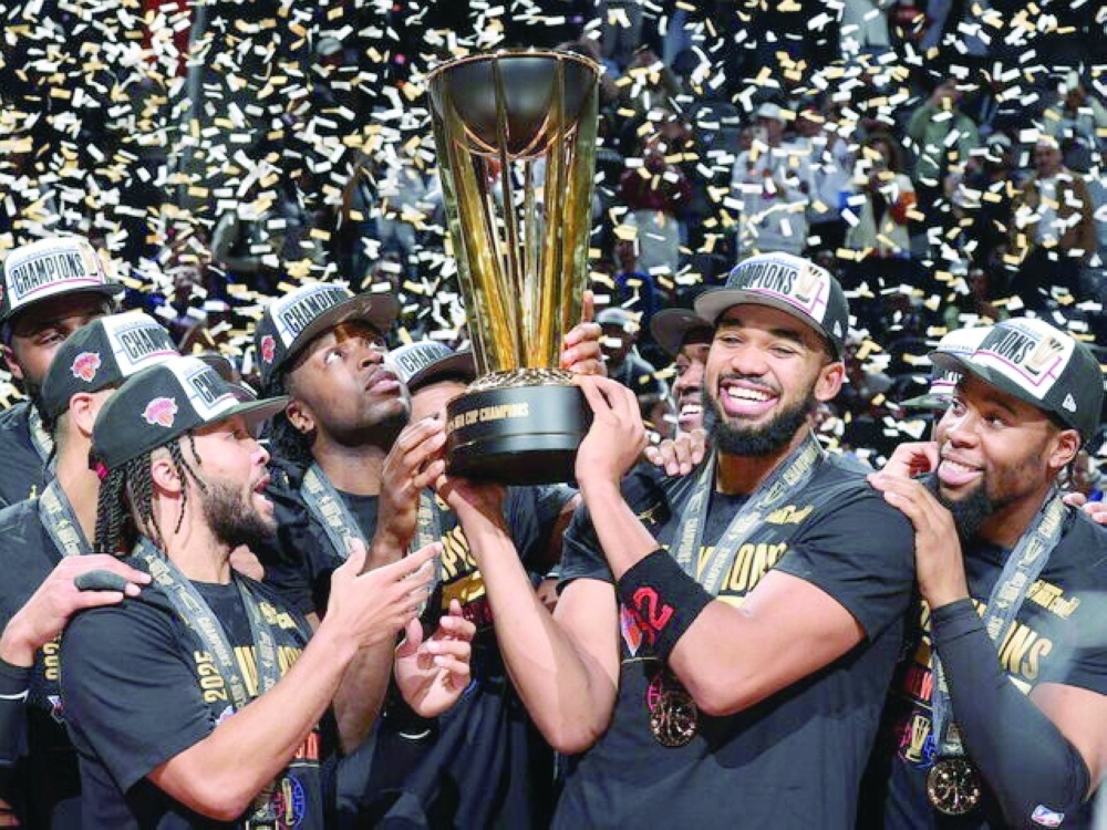 New York Knicks players celebrate with the NBA Cup trophy.