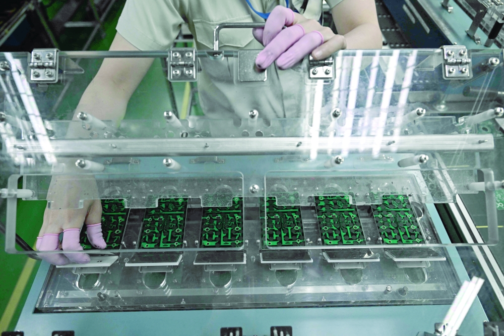 Workers assembling calculators at the Casio factory in Thailand's Nakhon Ratchasima province. — AFP
