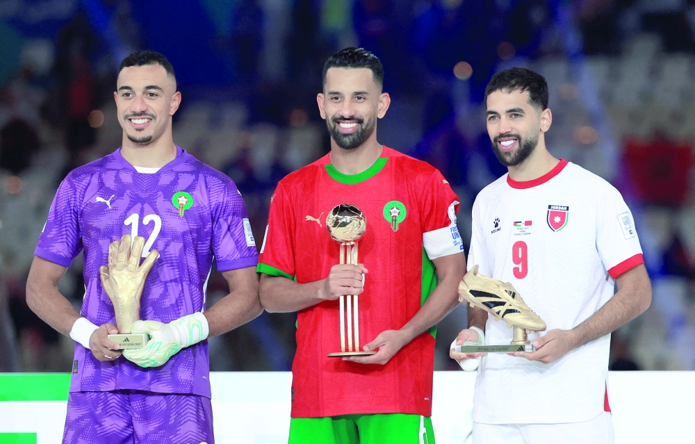 Soccer Football - FIFA Arab Cup - Qatar 2025 - Final - Jordan v Morocco - Lusail Stadium, Lusail, Qatar - December 18, 2025 Morocco's Mohamed Hrimat poses on the podium after winning the Best Player award along with Best Goalkeeper Morocco's El Mehdi Benabid and Top Goalscorer Jordan's Ali Olwan REUTERS/Thaier Al-Sudani