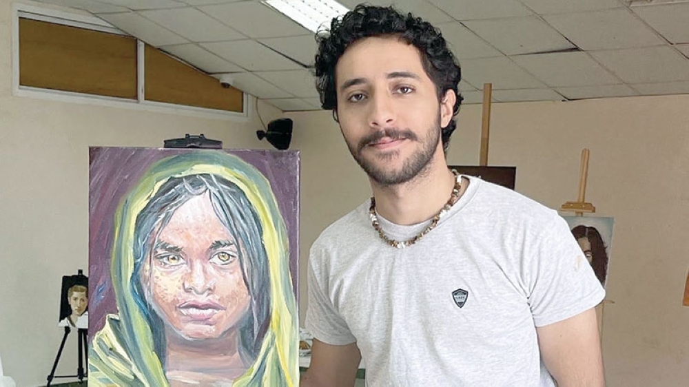 Hussain bin Abdullah al Ghamlasi with his art work