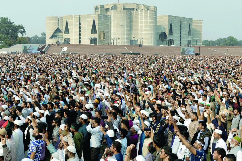 Mourners attend the funeral of the deceased youth leader Sharif Osman Hadi, in Dhaka on December 20, 2025.  Tens of thousands of mourners gathered in the Bangladeshi capital Dhaka on December 20 for the funeral of a student leader, after two days of violent protests over his killing. (Photo by Abdul Goni and Abdul Goni / AFP)