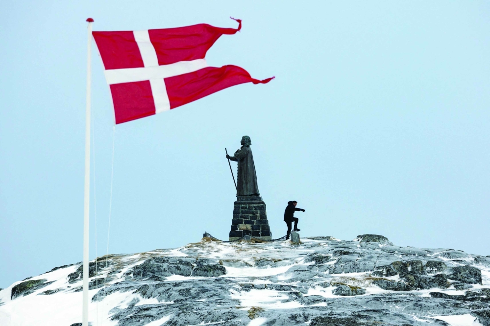 A man walks as Danish flag flutters next to Hans Egede Statue in Nuuk, Greenland. — Reuters file photo 
