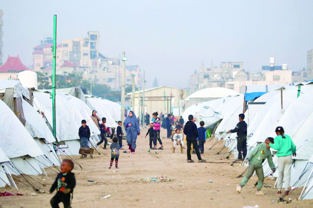 People walk amid shelters at the Nuseirat camp for displaced Palestinians. — AFP