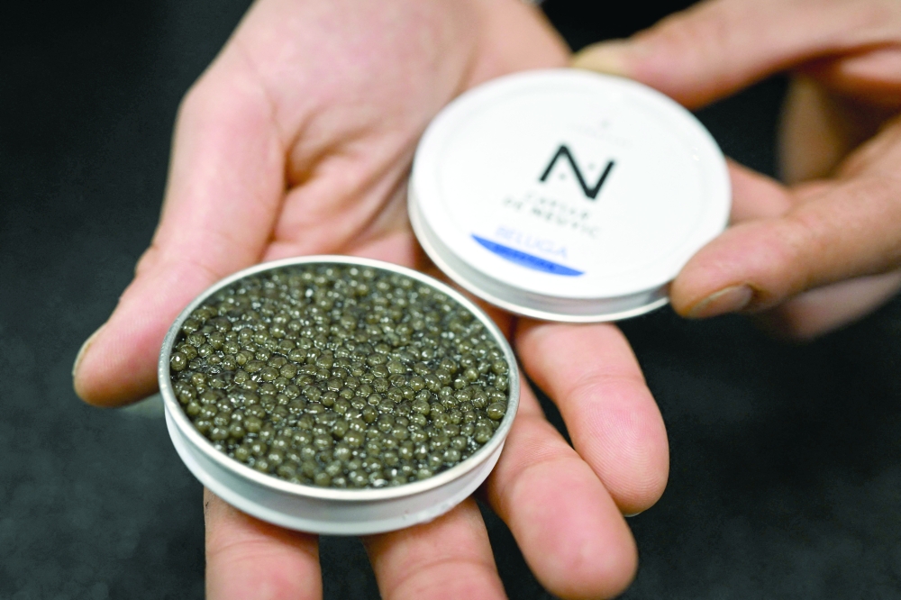 An employee shows an opened box of caviar at the Caviar de Neuvic boutique in Paris. — AFP