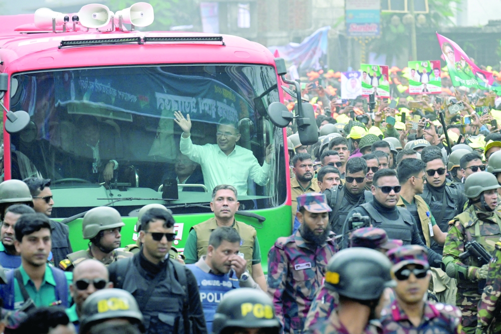 Tarique Rahman waves from a vehicle after his arrival in Dhaka. — Reuters