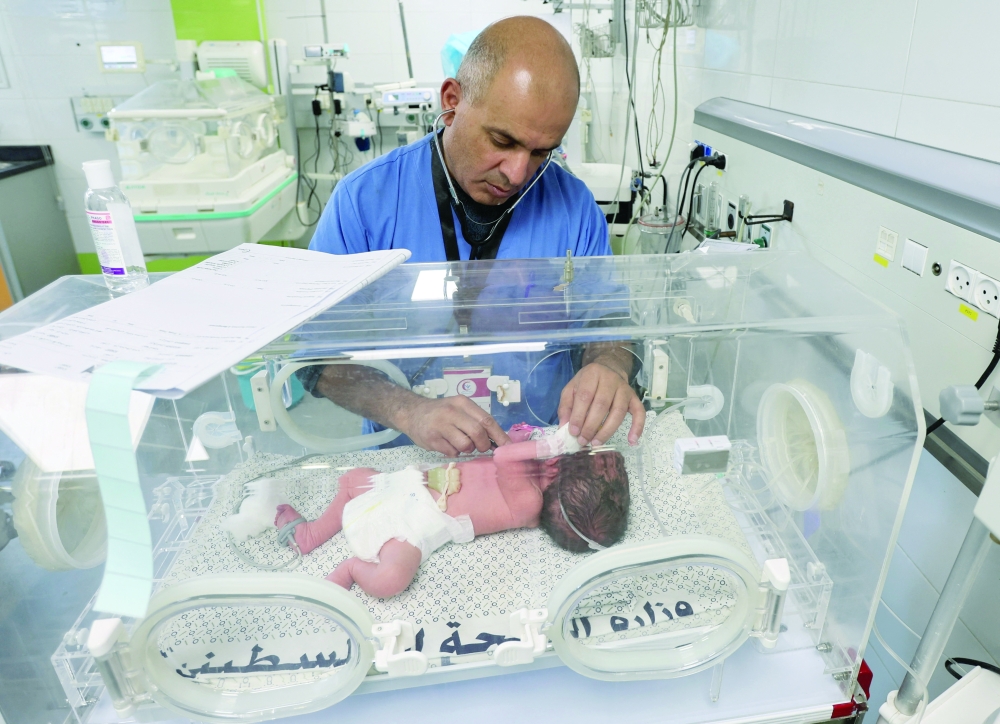 A medical worker examines a baby inside an incubator, amidst a cold wave affecting displaced families, at Nasser Hospital in Khan Yunis, southern Gaza Strip. — Reuters