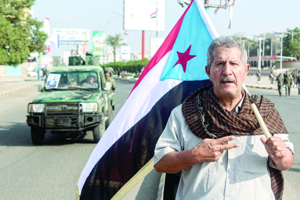 A man holds a People's Republic of South Yemen flag on the 58th anniversary of National Independence Day in the port city of Aden. — AFP File