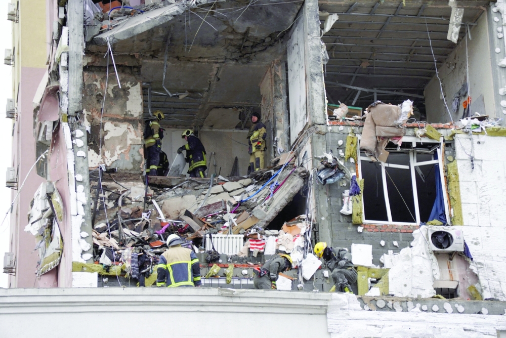 Ukrainian rescuers look through rubble inside a damaged building, in Kyiv. — AFP