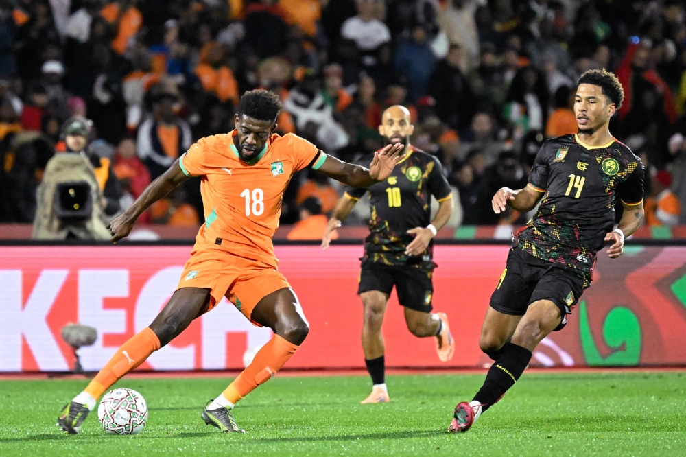 Ivory Coast's Ibrahim (L) fights for the ball with Cameroon's Namaso (R) 