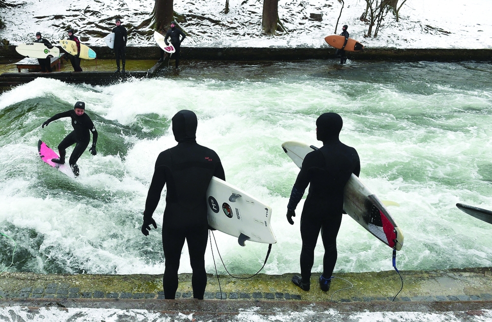 A surfer rides an artificial wave in the canal of the Eisbach (ice creek) river at the English Garden park in Munich, southern Germany. — AFP