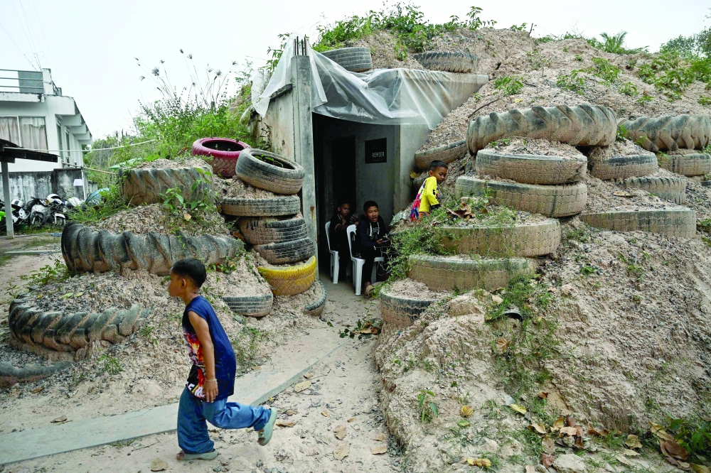 Children play around a bunker in Surin province during clashes along the border. — AFP