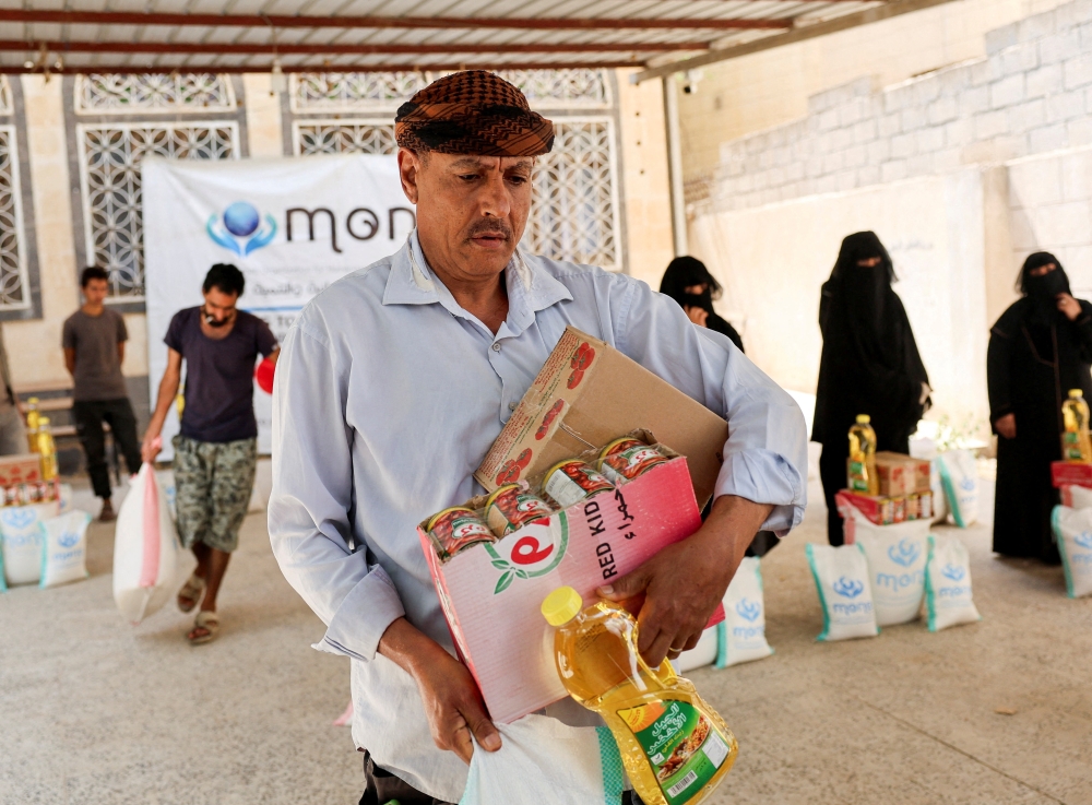 A man carries foodstuffs provided by the Yemeni charity