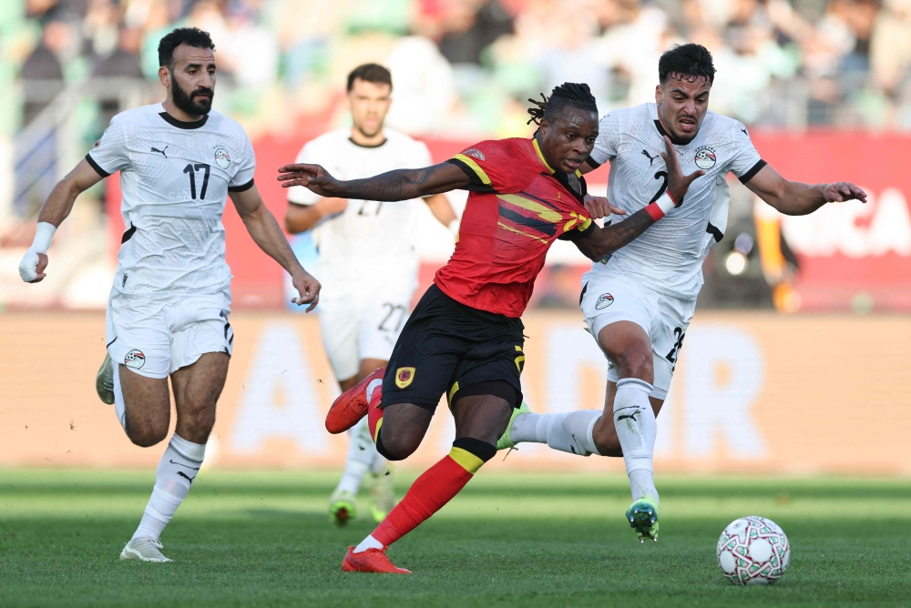 Angola's Modesto (C) fights for the ball with Egypt's Lasheen (L) and Ismail (R) 