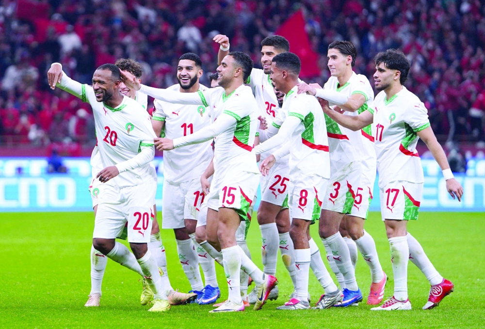 Morocco's Ayoub El Kaabi celebrates scoring their third goal with teammates. — Reuters