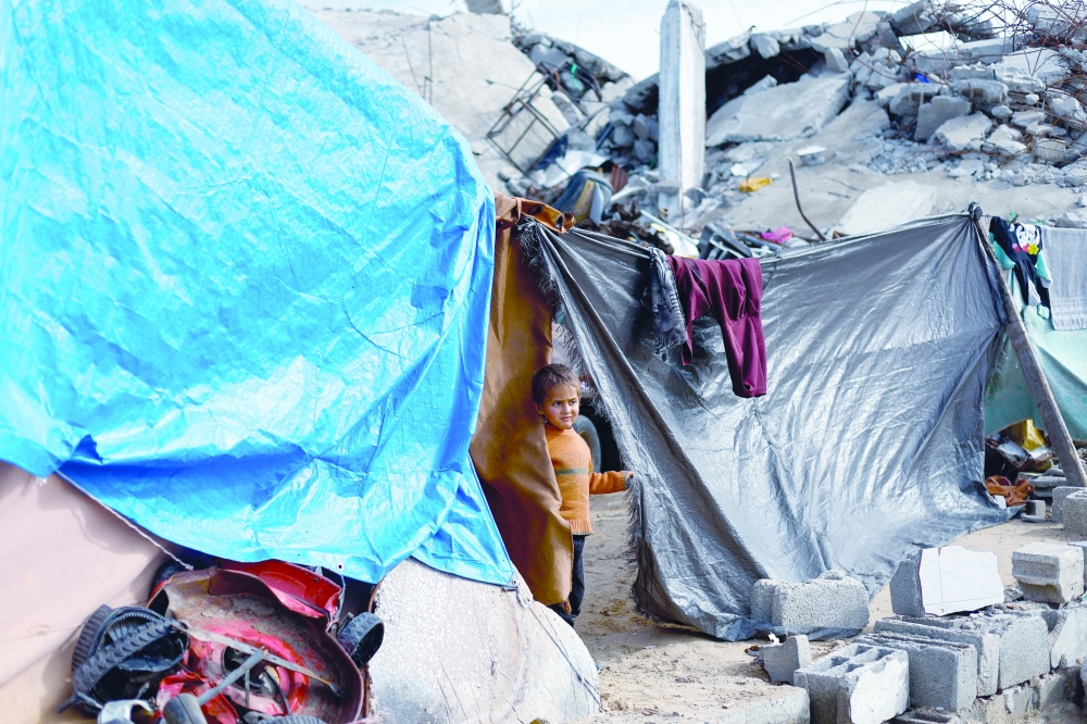 A displaced Palestinian child looks on from a tent in Jabalia, northern Gaza. — Reuters