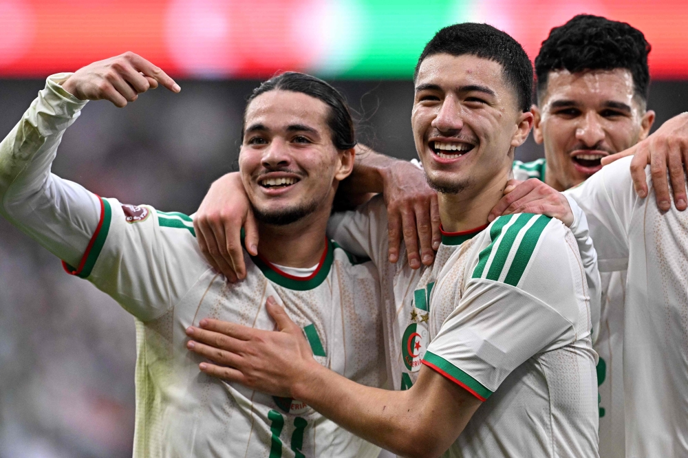 Algeria's midfielder #22 Ibrahim Maza (C) celebrates scoring his team's third goal with Algeria's forward #11 Anis Hadj Moussa 