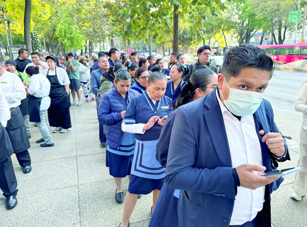 People wait outside their homes and buildings after an earthquake in Mexico City. — Reuters