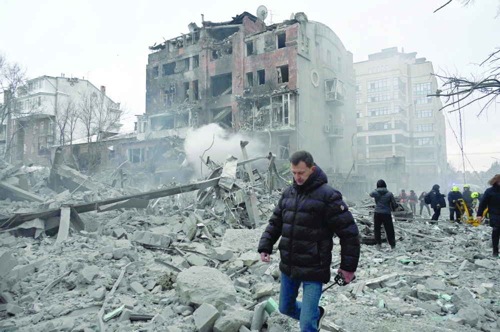 Residents stand next to damaged residential buildings following a Russian air strike in Kharkiv amidst the Russian war in Ukraine. — AFP