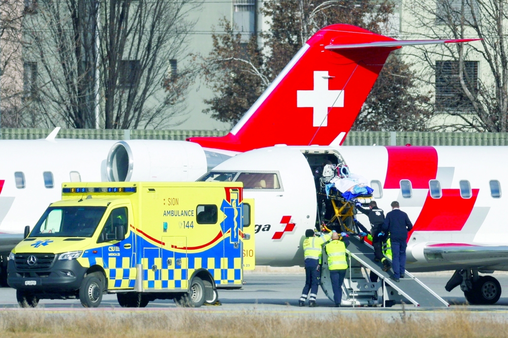Medical staff and airport personnel load a casualty onto a Swiss Air-Ambulance plane at Sion Airport following a fire and an explosion at the 'Le Constellation' bar, during a New Year's Eve party in Sion, Switzerland. — Reuters