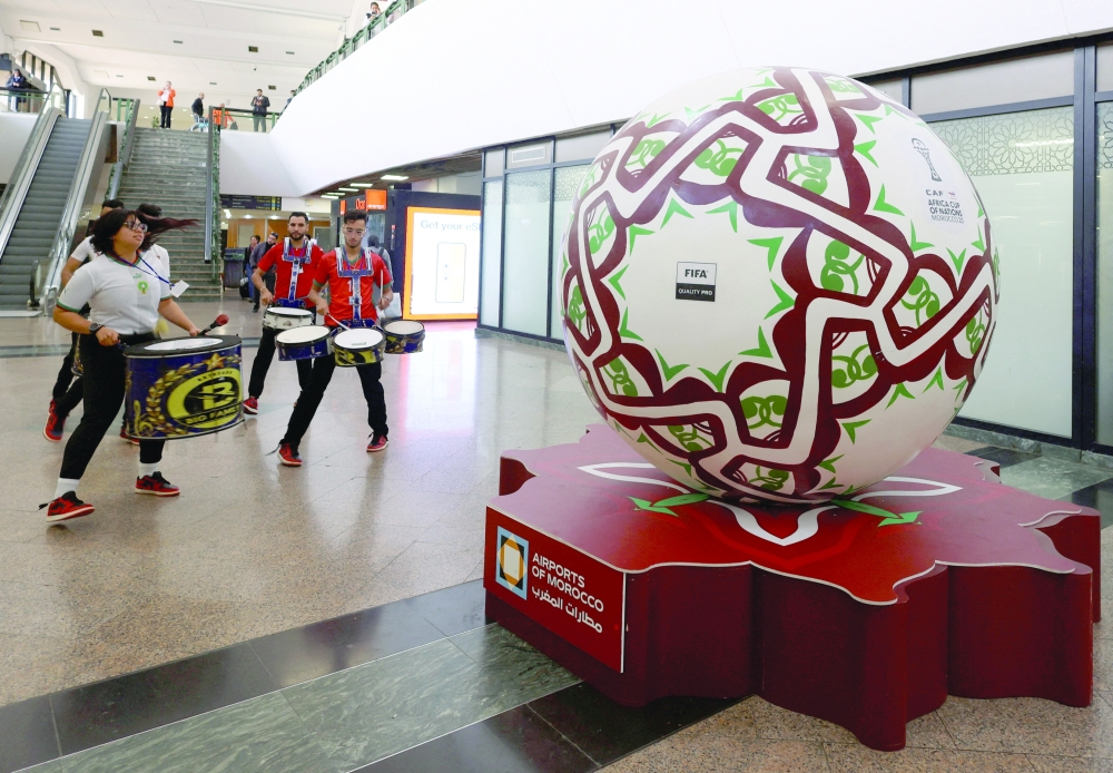 A giant replica of the official ball for the Africa Cup of Nations (AFCON) is displayed as volunteers and performers entertain travelers arriving at Mohammed V International Airport in Casablanca, Morocco, January 1, 2026. REUTERS/Amr Abdallah Dalsh