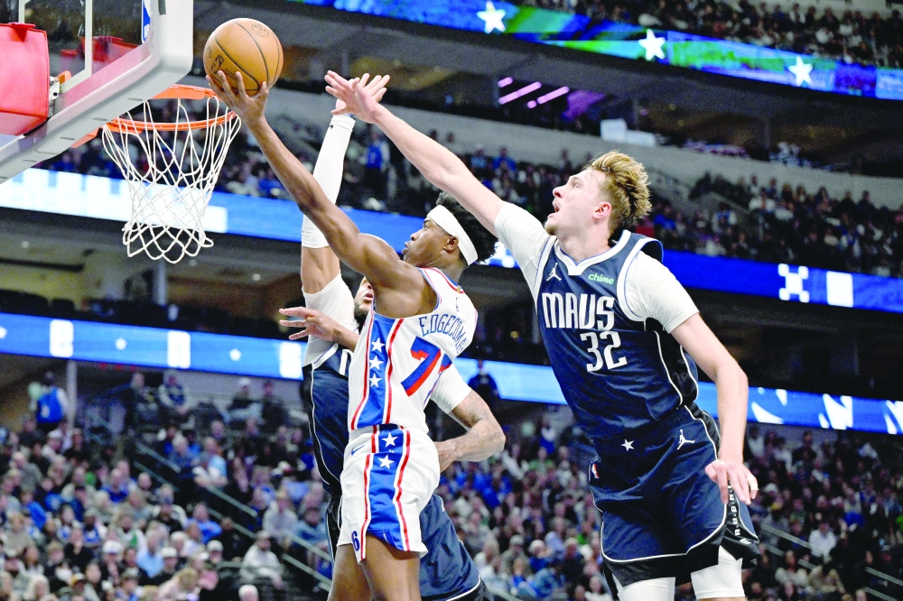 Jan 1, 2026; Dallas, Texas, USA; Philadelphia 76ers guard Vj Edgecombe (77) drives to the basket past Dallas Mavericks forward Daniel Gafford (21) and forward Cooper Flagg (32) during the second half at the American Airlines Center. — Imagn Images