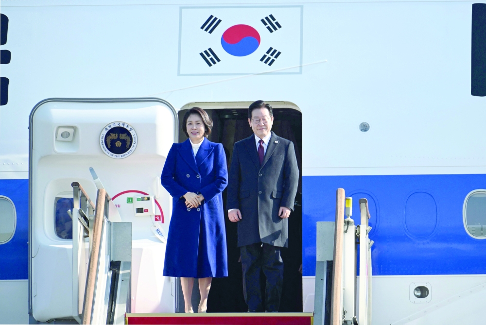 South Korea President Lee Jae Myung (R) and his wife Kim Hea Kyung (L) board their plane to depart for China at Seoul Air Base. — AFP