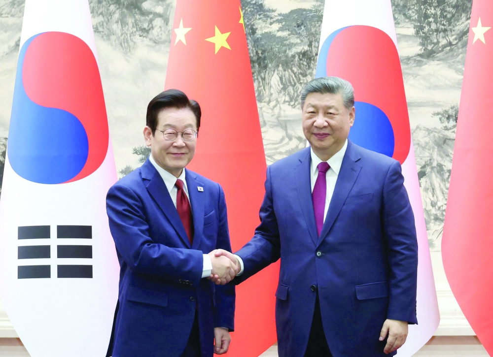 South Korea's President Lee Jae Myung (L) shakes hands with China's President Xi Jinping (R), at the Great Hall of the People in Beijing. — AFP