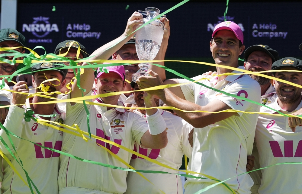 Australia's Steve Smith and Pat Cummins celebrate on the podium with teammates