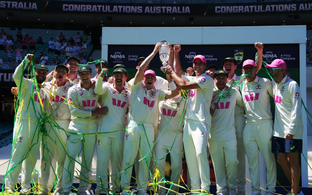 Australia's Steve Smith and Pat Cummins celebrate on the podium with teammates