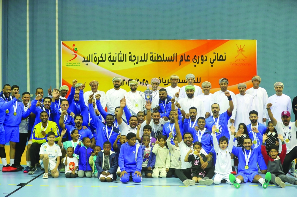 Al Amerat players celebrate with the trophy and gold medals.