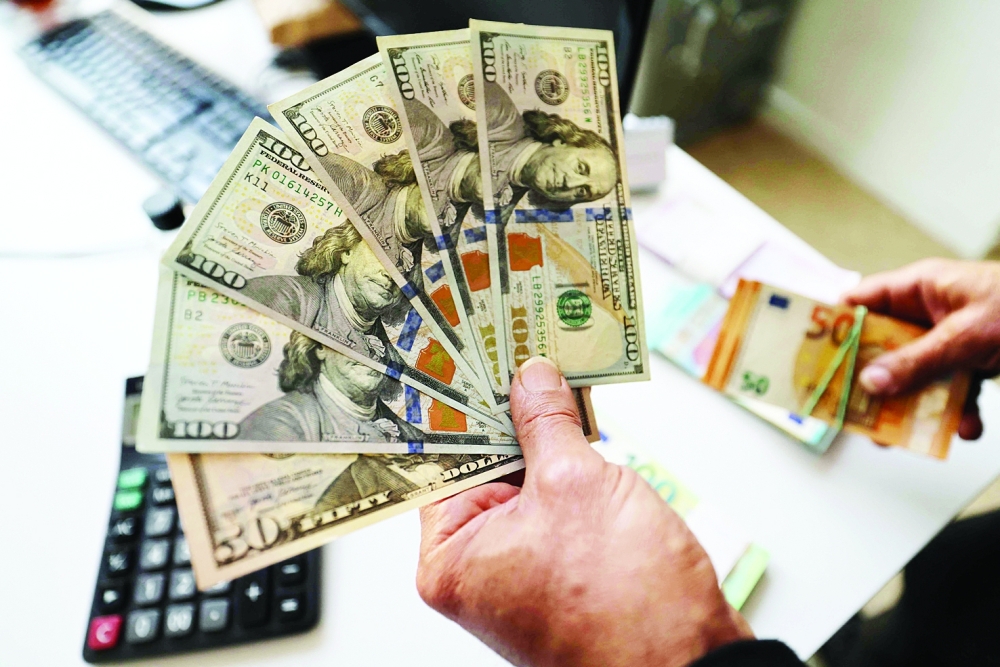 An Iranian man shows US dollar banknotes in a currency exchange office in a shopping centre in Tehran on January 7, 2026 . Iran's economy has been hit hard by tough international sanctions, with the national currency, the rial, losing more than a third of its value against the US dollar over the past year and inflation in double digits. (Photo by ATTA KENARE / AFP)
