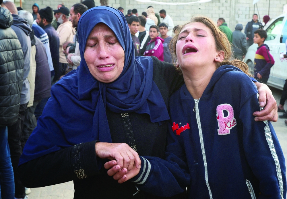 Family members mourn the death of a Palestinian killed in an Israeli strike in Khan Yunis on Thursday. — AFP