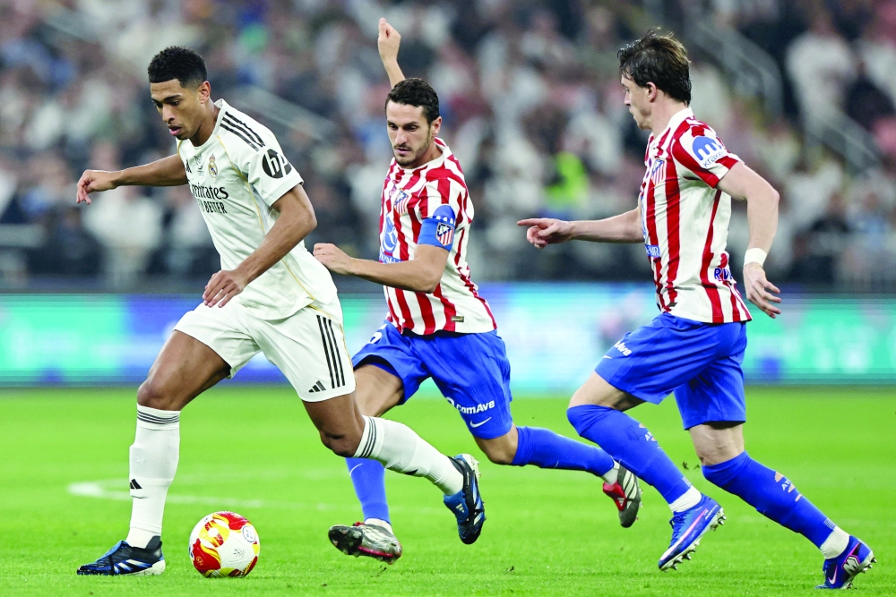 Atletico Madrid's English midfielder #04 Conor Gallagher and Real Madrid's French midfielder #06 Eduardo Camavinga chase Real Madrid's English midfielder #05 Jude Bellingham during the Spanish Supercup semi-final football match between Atletico Madrid and Real Madrid at King Abdullah Sports City in Jeddah on January 8, 2026. (Photo by Fadel SENNA / AFP)