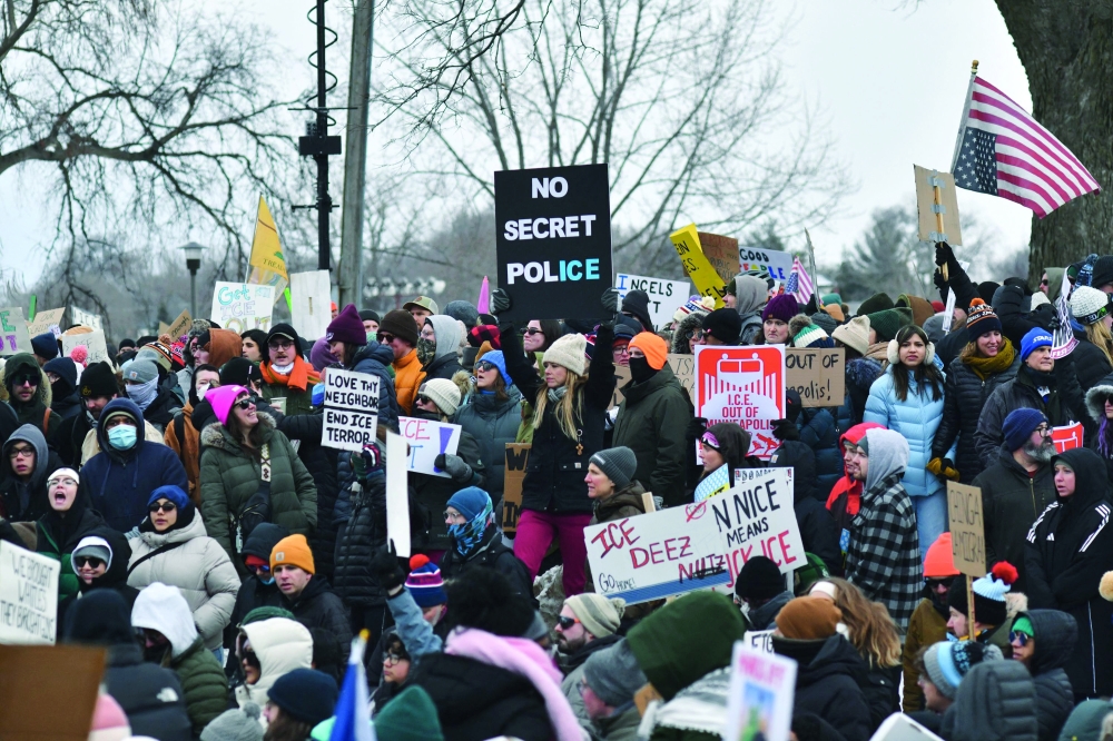 Protesters hold signs as they march from Powderhorn Park in Minneapolis. — AFP