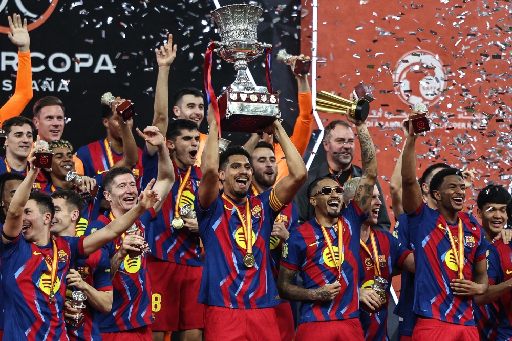 Barcelona's players raise the trophy as they celebrate after the winning
